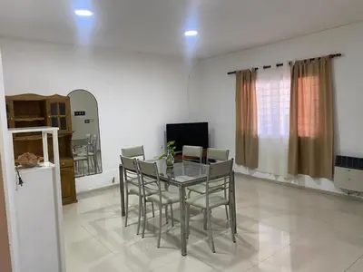 a dining room with a glass table and chairs at El Búho Apart in Villa Parque Siquiman