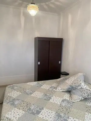 a bedroom with a bed with a brown cabinet at El Búho Apart in Villa Parque Siquiman