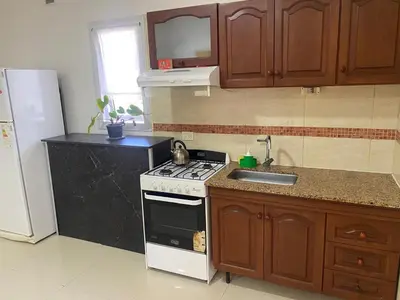 a kitchen with a stove and a sink and a refrigerator at El Búho Apart in Villa Parque Siquiman