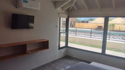a room with a tv and a window with a view at Apart Ladera Sur in Arroyo de Los Patos