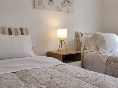 a bedroom with two beds and a table with a lamp at Casa para 5 Personas en Villa Cabrera con Garage in Cordoba