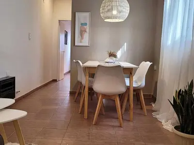 a dining room with a table and white chairs at Casa para 5 Personas en Villa Cabrera con Garage in Cordoba