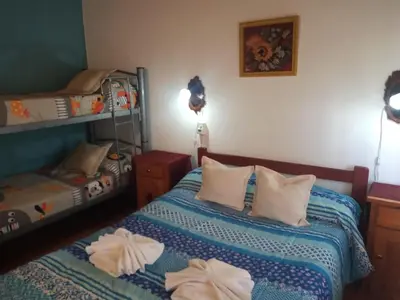 a bedroom with two beds and a bunk bed at Casa Bela in Villa Carlos Paz