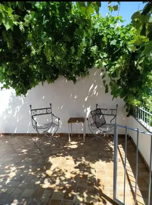 two metal chairs and a table under a tree at Casa Bela in Villa Carlos Paz