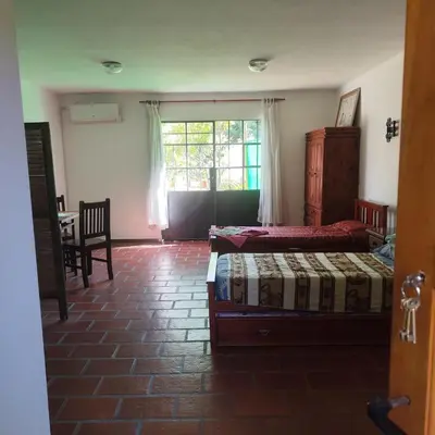a bedroom with two beds and a table and a window at Departamento interno Excelente ubicación in Alta Gracia