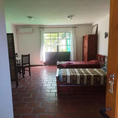 a bedroom with two beds and a table and a window at Departamento interno Excelente ubicación in Alta Gracia