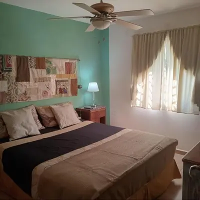 a bedroom with a bed with a ceiling fan at Parques del Chateau in Cordoba