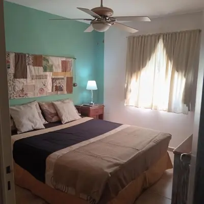 a bedroom with a bed and a ceiling fan at Parques del Chateau in Cordoba
