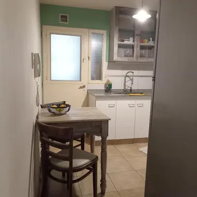 a kitchen with a table and chairs and a sink at Parques del Chateau in Cordoba