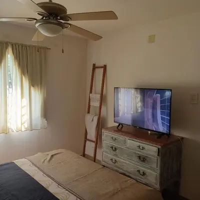 a bedroom with a flat screen tv on a dresser at Parques del Chateau in Cordoba