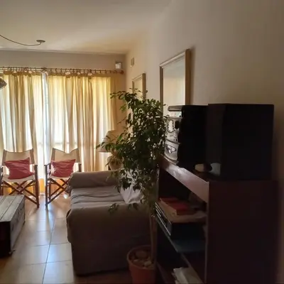 a living room with a couch and a plant at Parques del Chateau in Cordoba