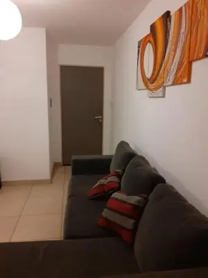 a living room with a couch with two pillows on it at Mi depto en alta Cba in Cordoba