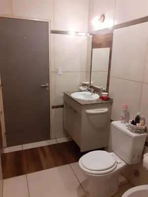 a bathroom with a toilet and a sink and a mirror at Mi depto en alta Cba in Cordoba
