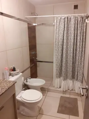 a bathroom with a toilet and a shower curtain at Mi depto en alta Cba in Cordoba