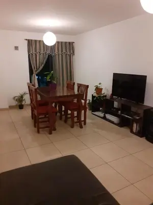 a living room with a table and chairs and a television at Mi depto en alta Cba in Cordoba