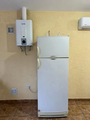 a white refrigerator in a room with a wall at La casita de Oli in Tanti