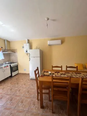 a kitchen with a table and chairs and a refrigerator at La casita de Oli in Tanti
