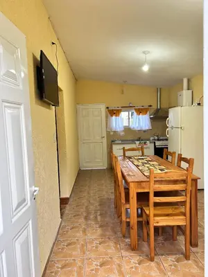 a dining room with a table and a kitchen at La casita de Oli in Tanti