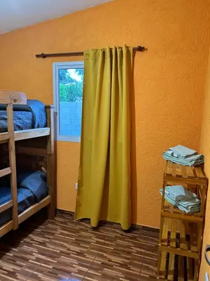 a room with a yellow curtain and a window at La casita de Oli in Tanti