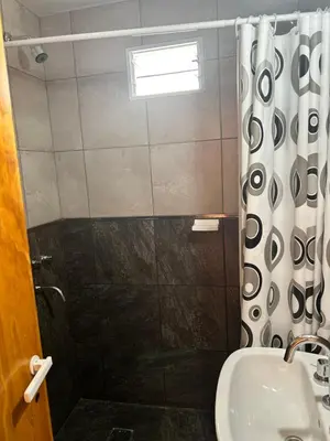 a bathroom with a shower curtain and a sink at La casita de Oli in Tanti