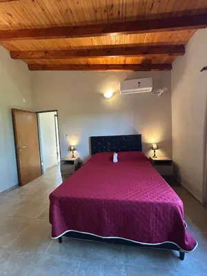 a bedroom with a large bed with a purple bedspread at Refugio de las nubes in Las Rabonas