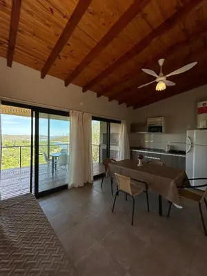 a living room with a ceiling fan and a table at Refugio de las nubes in Las Rabonas