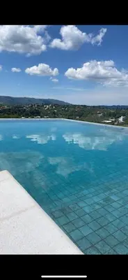 a large pool of water with a view of the ocean at Cabañas Las Marias - Mirador del Lago in Villa Parque Siquiman
