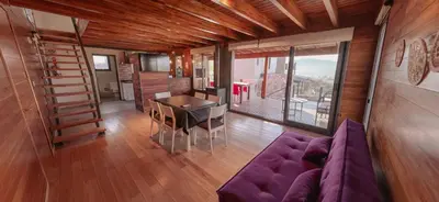 a living room with a purple couch and a table at Cabañas Las Marias - Mirador del Lago in Villa Parque Siquiman