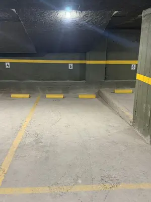 a parking garage with yellow barriers in a parking lot at Departamento Premium Aqua II in Villa Carlos Paz