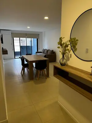 a living room with a table and a mirror at Departamento Premium Aqua II in Villa Carlos Paz