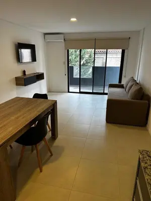 a living room with a couch and a table at Departamento Premium Aqua II in Villa Carlos Paz