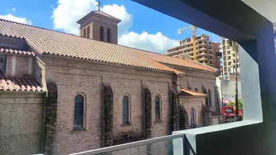 a large brick building with a clock tower at Departamento Premium Aqua II in Villa Carlos Paz