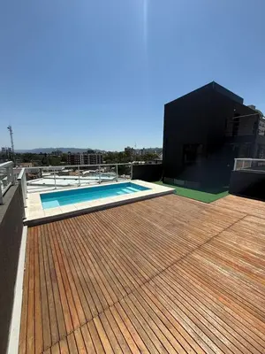a deck with a swimming pool on top of a building at Departamento Premium Aqua II in Villa Carlos Paz