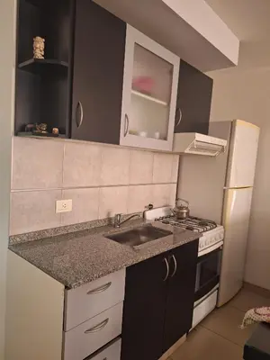 a kitchen with a sink and a stove and refrigerator at La Plata in Villa Carlos Paz
