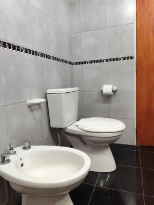 a bathroom with a white toilet and a sink at Complejo Gabriel - Departamentos Temporarios in Villa Carlos Paz