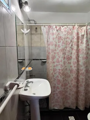 a bathroom with a sink and a shower curtain at Complejo Gabriel - Departamentos Temporarios in Villa Carlos Paz