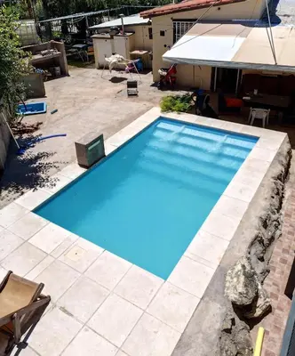 a large blue swimming pool in a yard at Complejo Gabriel - Departamentos Temporarios in Villa Carlos Paz
