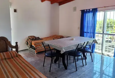 a dining room with a table and chairs and a bed at Complejo Gabriel - Departamentos Temporarios in Villa Carlos Paz