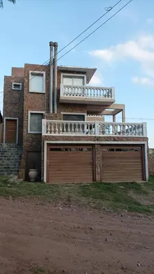 a house with two garage doors in front of it at Casa montaña & jacuzzi in Embalse