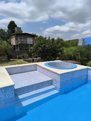 a blue swimming pool with stairs and a swimming poolvisor at Casa montaña & jacuzzi in Embalse