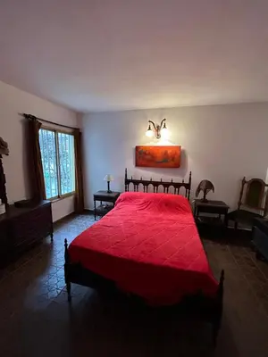 a bedroom with a red bed with a red blanket at Casa Jazmín in Villa Carlos Paz