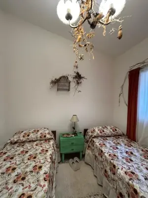 a bedroom with two beds and a green night stand at Casa Jazmín in Villa Carlos Paz