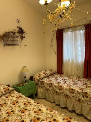 a bedroom with two beds and a chandelier at Casa Jazmín in Villa Carlos Paz