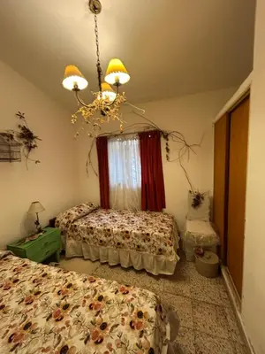 a bedroom with two beds and a chandelier at Casa Jazmín in Villa Carlos Paz
