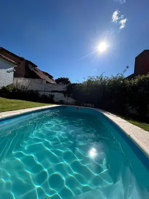 a swimming pool with the sun in the sky at Casa Jazmín in Villa Carlos Paz
