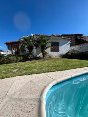 a house with a swimming pool in front of a house at Casa Jazmín in Villa Carlos Paz