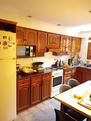 a kitchen with wooden cabinets and white appliances at CASA RIO TERCERO Cordoba Argentina in Río Tercero