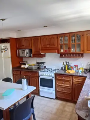 a kitchen with wooden cabinets and a white stove top oven at CASA RIO TERCERO Cordoba Argentina in Río Tercero