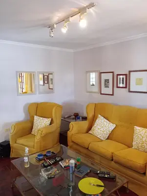 a living room with two yellow couches and a coffee table at CASA RIO TERCERO Cordoba Argentina in Río Tercero