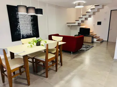 a dining room with a table and chairs and a couch at Duplex temporario en Villa Carlos Paz in Villa Carlos Paz